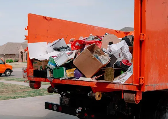 Orange junk removal truck filled with assorted junk for same-day removal in Plantation, FL, highlighting quick and reliable service.